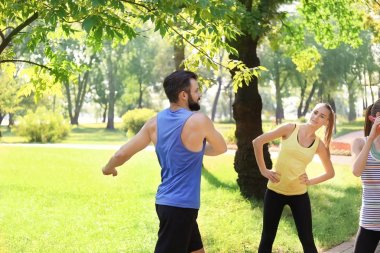 Bir grup genç insan parkta çalıştırdıktan sonra dinlenme