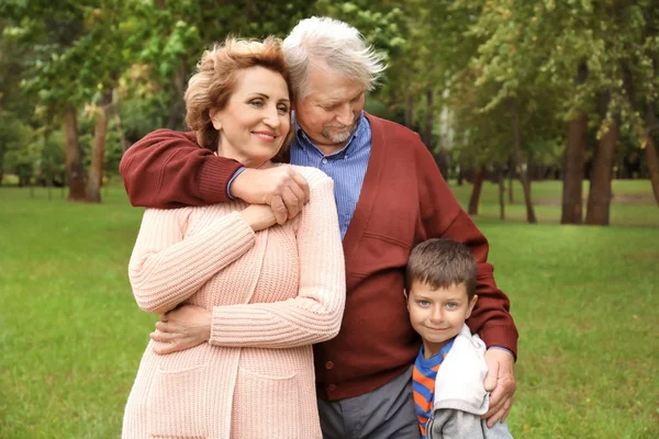 Felice coppia anziana con nipote nel parco — Foto Stock