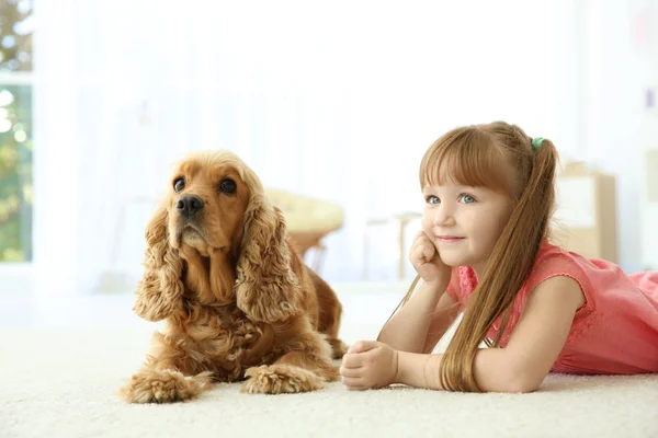 Söt liten flicka med hund hemma — Stockfoto