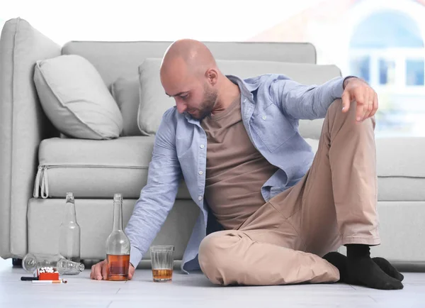Pijany Mężczyzna Siedzi Podłodze Domu Pojęcie Alkoholizmu — Zdjęcie stockowe
