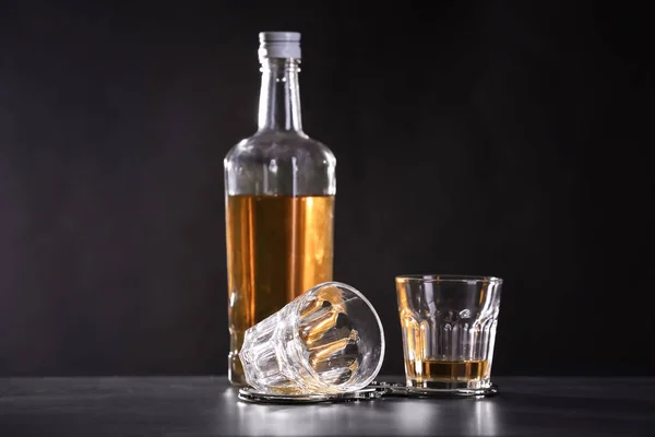 Flasche Und Brille Mit Handschellen Auf Dunklem Hintergrund Alkoholabhängigkeit — Stockfoto