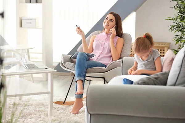 Busy young woman with daughter in home office — Stock Photo, Image