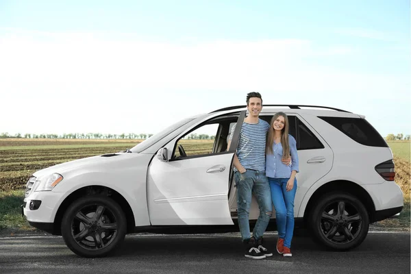 Όμορφο νεαρό ζευγάρι στέκεται κοντά σε υπαίθρια αυτοκινήτου — Φωτογραφία Αρχείου