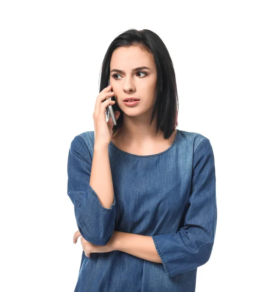 Молодая женщина говорит по мобильному телефону на белом фоне — стоковое фото