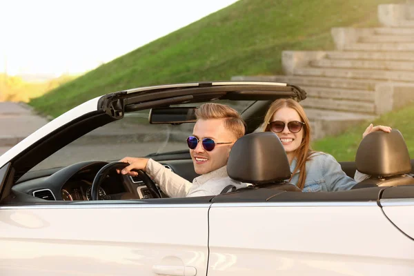 Heureux jeune couple en voiture sur la route — Photo