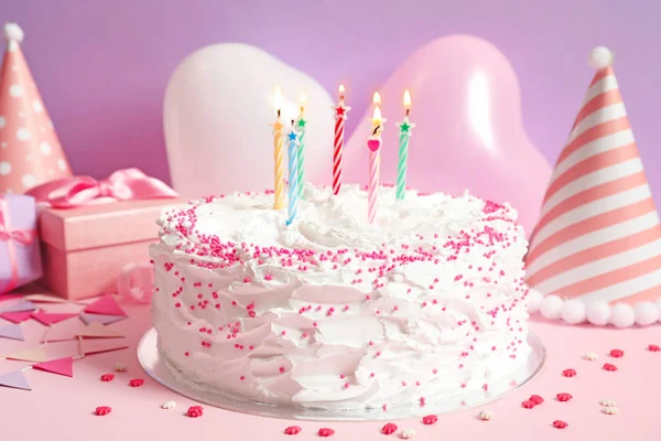 Torta di compleanno con candele sul tavolo contro la parete a colori — Foto Stock