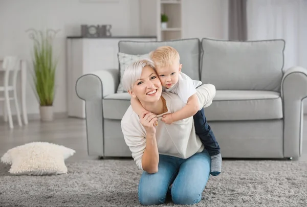 Attraktiv ung mamma leker med hennes baby hemma — Stockfoto