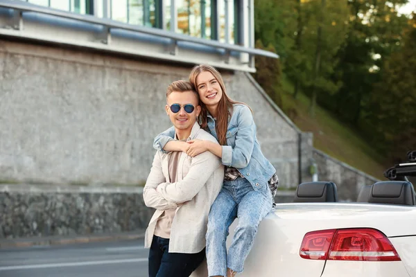 Felice giovane coppia che abbraccia vicino auto — Foto Stock