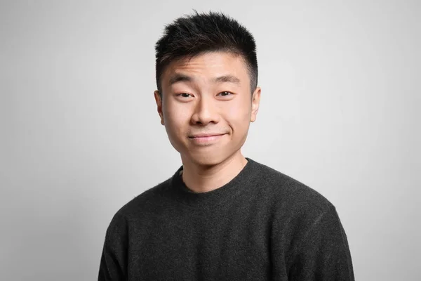 Portrét mladé asijské člověka na světlé pozadí — Stock fotografie