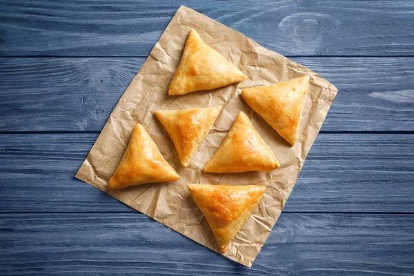 Lahodný pečený samosas na dřevěný stůl — Stock fotografie