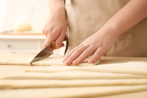 Woman cutting puff pastry on table — Stock Photo, Image