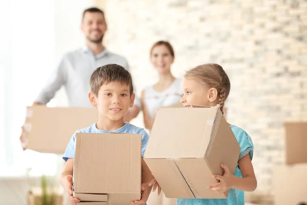 Familia feliz con cajas de cartón en piso nuevo — Foto de Stock