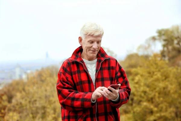 Krásný zralý muž venku pomocí telefonu — Stock fotografie