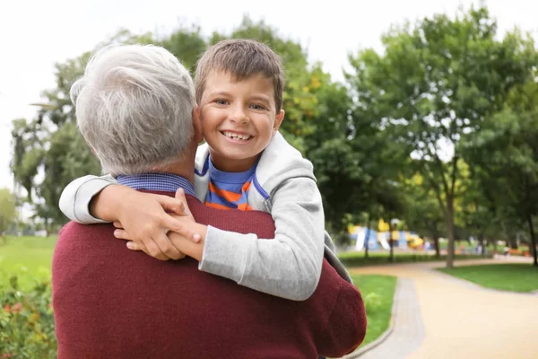 Счастливый старший мужчина с внуком в парке — стоковое фото