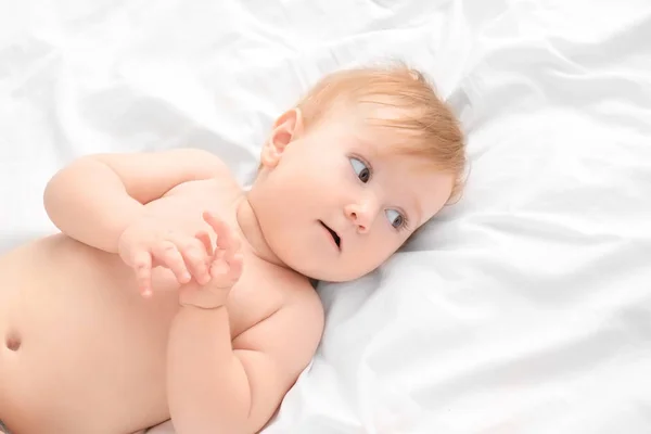 Bonito pouco bebê deitado em cima da cama — Fotografia de Stock