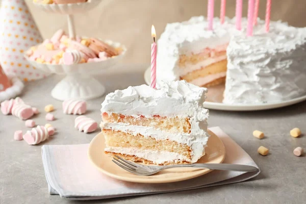 Kus narozeninový dort se svíčkou na stole — Stock fotografie