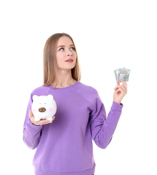 ผู้หญิงสาวถือธนาคารหมูและเงินบนพื้นหลังสีขาว — ภาพถ่ายสต็อก