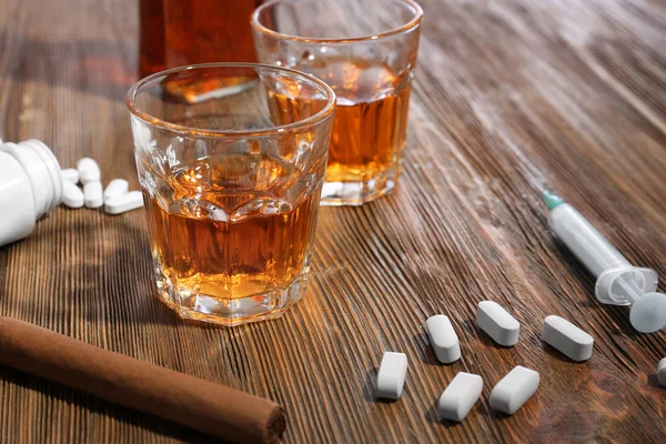 Composition with alcohol, cigar and drugs on wooden table. Concept of bad habits — Stock Photo, Image