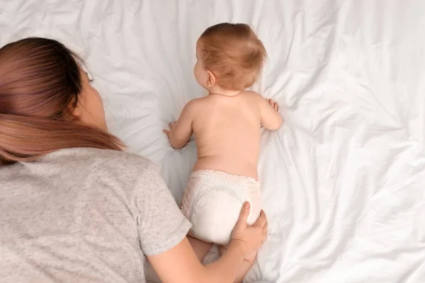 Ibu muda bermain dengan bayinya yang lucu di tempat tidur — Stok Foto