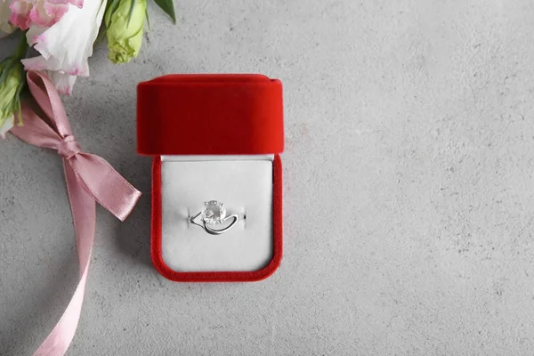 Caixa com anel de noivado de luxo no fundo cinza, vista superior — Fotografia de Stock