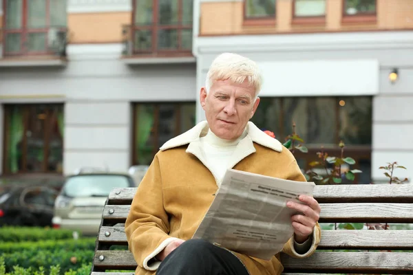 Yakışıklı olgun adam bankta açık havada gazete okuma — Stok fotoğraf