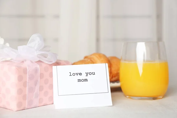 Nota con texto LOVE YOU MOM, caja de regalo y desayuno para el día de la madre en la mesa —  Fotos de Stock