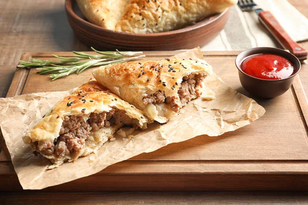 Placa de madeira com deliciosa carne samosa e molho na mesa — Fotografia de Stock