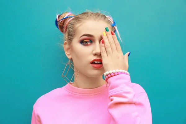 Молодая женщина с радужным макияжем на цветном фоне — стоковое фото