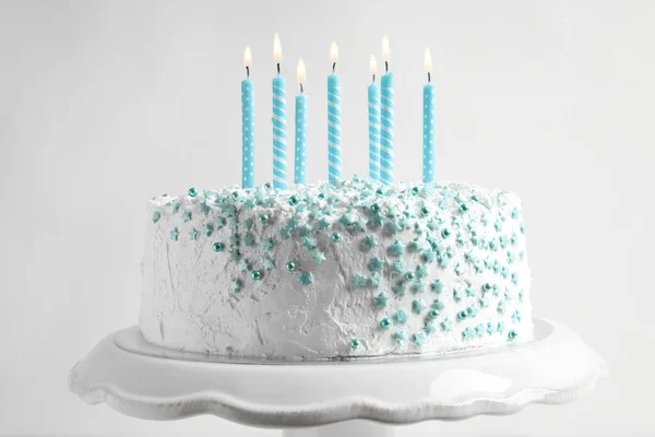 Stand with birthday cake and candles on light background — Stock Photo, Image