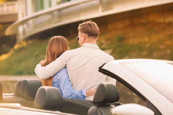 Счастливая молодая пара стоит рядом с современным автомобилем на открытом воздухе — стоковое фото