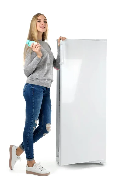 Jovem mulher tomando iogurte da geladeira no fundo branco — Fotografia de Stock