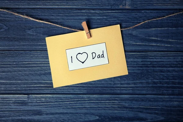 一张 "我爱爸爸" 的卡片, 上面有一串反对木制背景的父亲节 — 图库照片