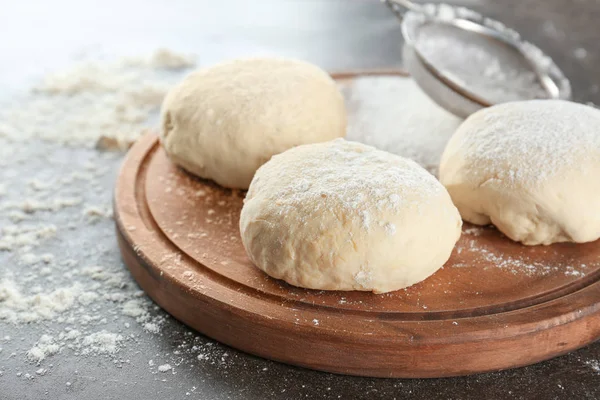 Raw dough balls on wooden board