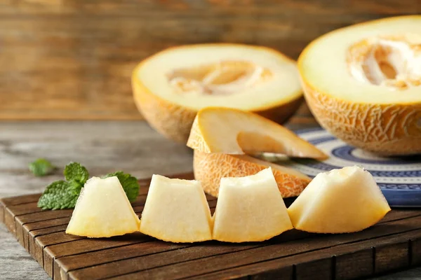 Wooden board with yummy melon slices on table — Stock Photo, Image