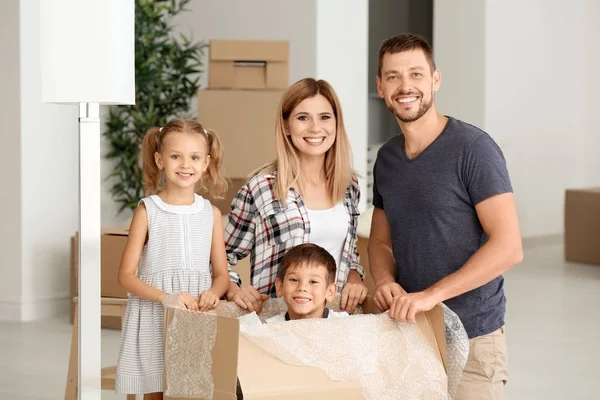 Familia feliz desempacando cosas en nuevo piso — Foto de Stock