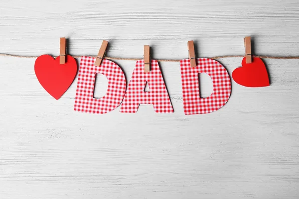 Parola "Papà" fatta di lettere di carta come saluto per la festa del papà su spago sullo sfondo di legno — Foto Stock