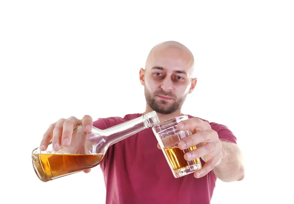 Muž, nalil whisky do skla proti Bílému pozadí. Koncepce alkoholismu — Stock fotografie