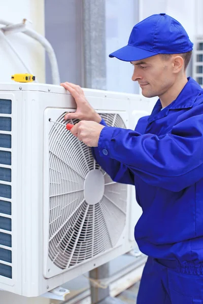 Männlicher Techniker repariert Klimaanlage im Freien — Stockfoto