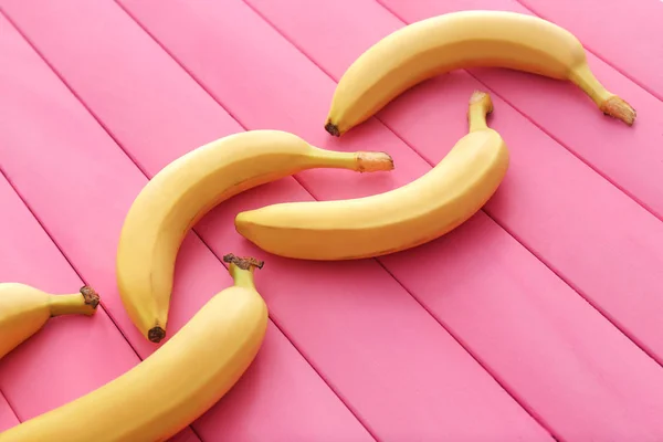 Композиція зі смачними стиглими бананами на кольоровому дерев'яному фоні — стокове фото