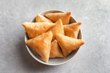 Işık arka plan üzerinde lezzetli samosas ile kase