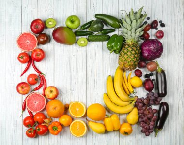 Meyve ve sebze gökkuşağı renkleri, düz ahşap arka plan üzerinde yapılmış yaratıcı kompozisyon yatıyordu