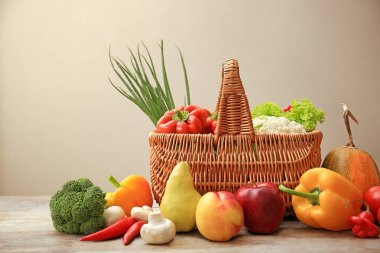 Hasır sepet farklı meyve ve sebzeler üzerinde gri bir arka plana dayanır ahşap masa