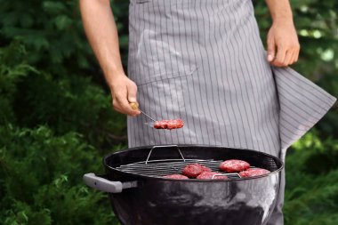 Adam açık havada mangal üzerinde leziz köftesi hazırlanıyor
