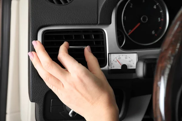 Kvinna justera luftkonditioneringen i bilen, närbild — Stockfoto