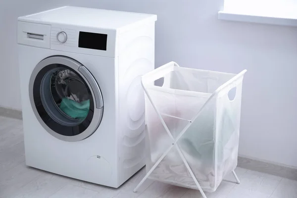 Cesta de lavandería y lavadora en interiores — Foto de Stock