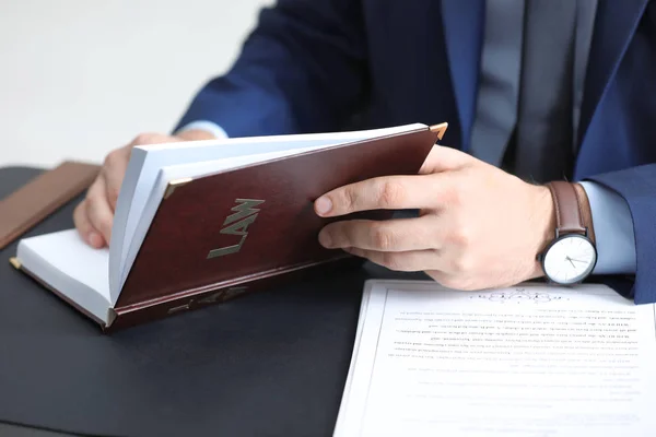 Młody mężczyzna notariusza z książki przy stole, zbliżenie — Zdjęcie stockowe