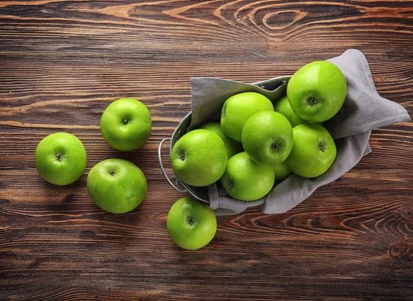 Košík s čerstvým Zelená jablka na dřevěné pozadí — Stock fotografie
