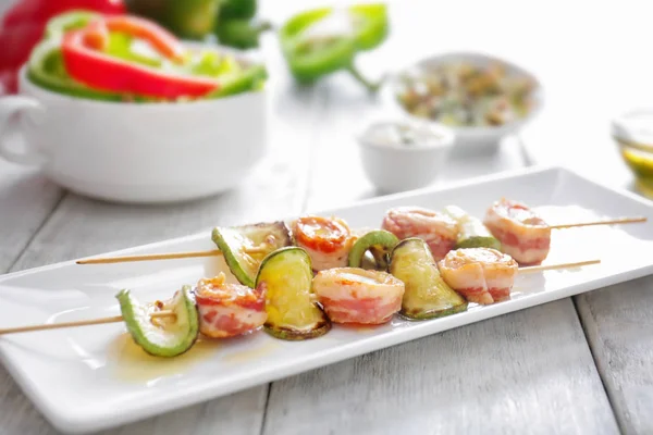 Plaat met bacon wrapped Sint-Jacobsschelpen op tafel — Stockfoto