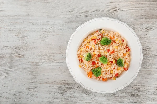 Prato com arroz pilaf e brócolis sobre mesa de madeira — Fotografia de Stock