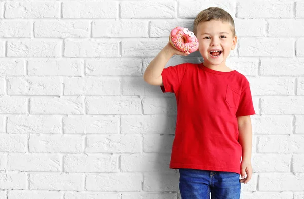 Jongetje Met Zoete Donut Buurt Van Witte Bakstenen Muur — Stockfoto